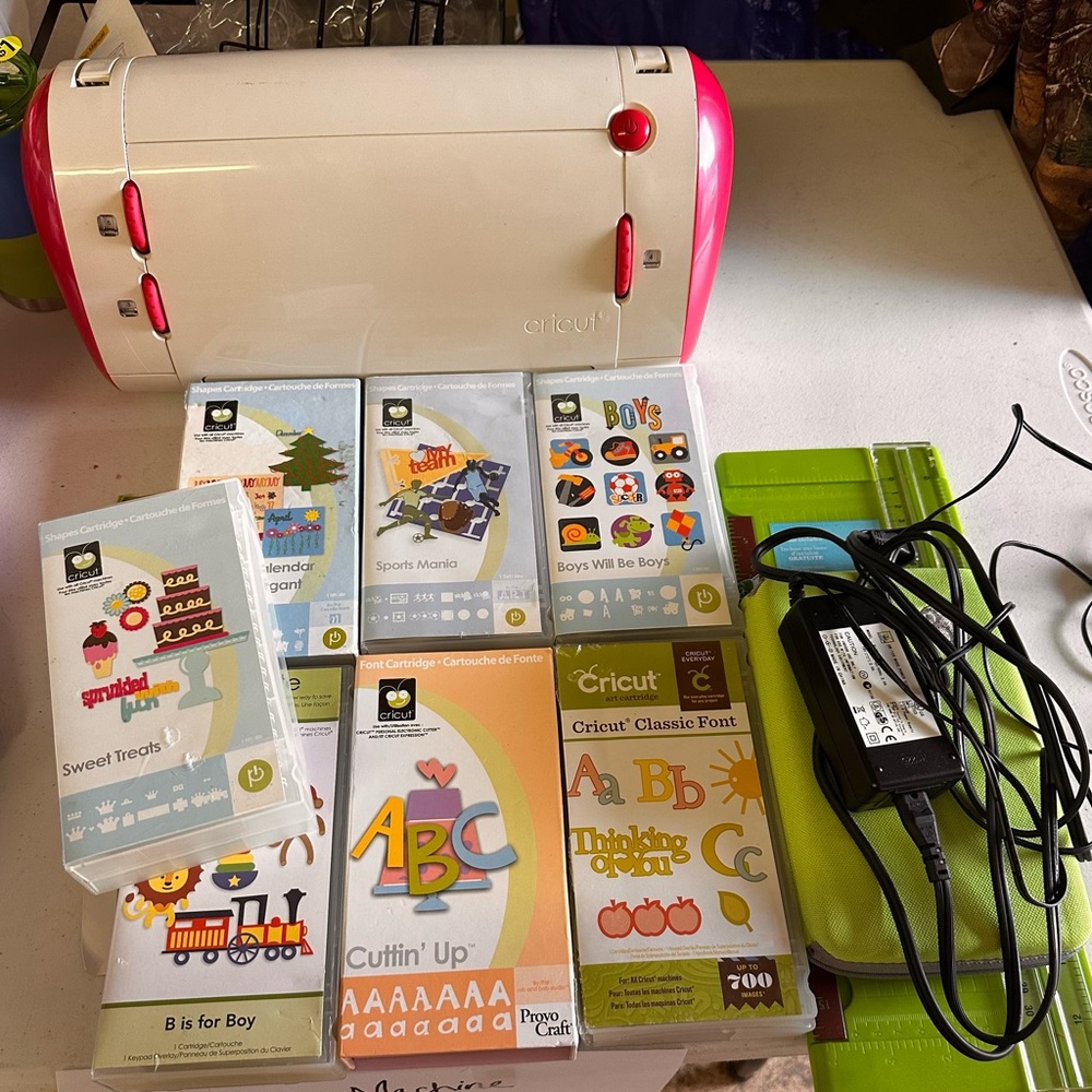 Cricut White and Red Crafting Machine with cartridges and accessories.